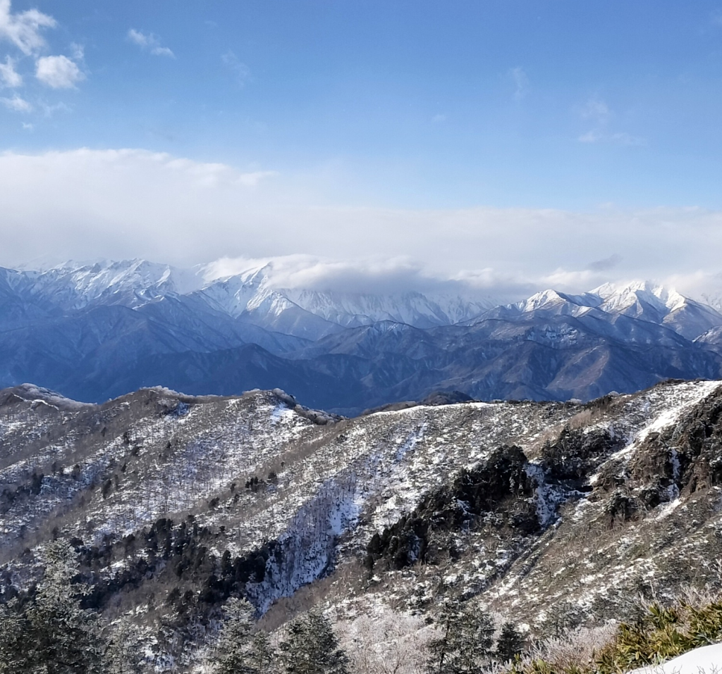 束の間の青空、谷川岳は雪雲に覆われている